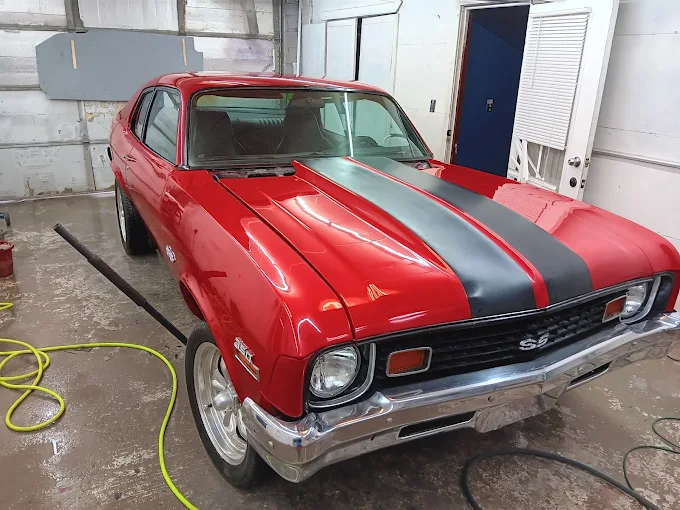 Professional auto body repair garage with polished car